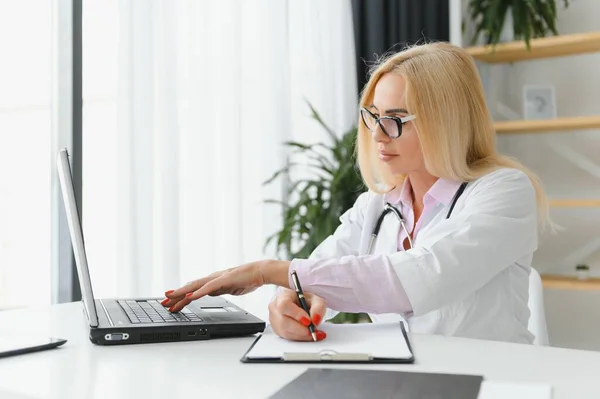 Retrato Una Doctora Mediana Edad Sentada Escritorio Trabajando Consultorio Médico — Foto de Stock