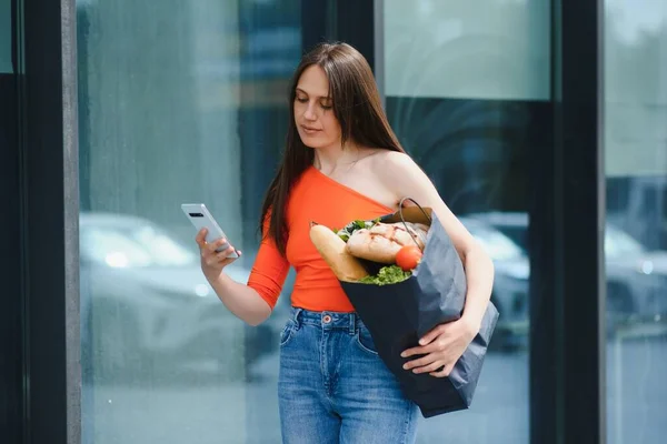 Mujer Joven Pie Cerca Tienda Con Paquete Alimentos — Foto de Stock