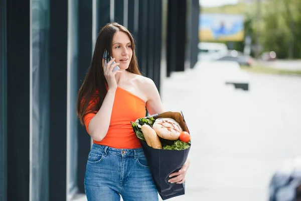 Mujer Joven Pie Cerca Tienda Con Paquete Alimentos — Foto de Stock
