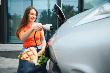 Kadın kiralık elektrikli araba kullanıyor..