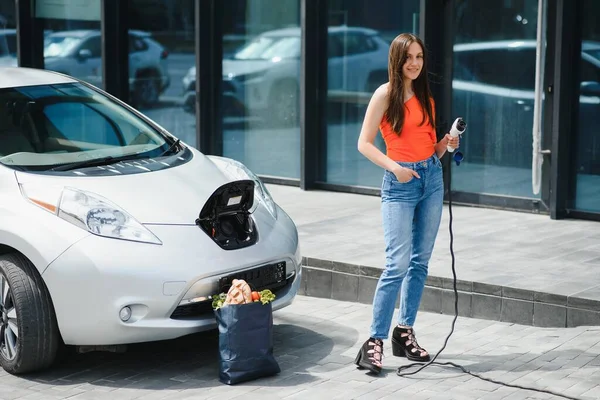 Kobieta Ładuje Wypożyczony Samochód Elektryczny — Zdjęcie stockowe