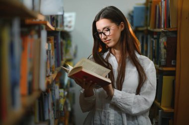 bir kitaplıktaki güzel bir öğrenci portresi.