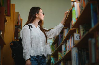 bir kitaplıktaki güzel bir öğrenci portresi.