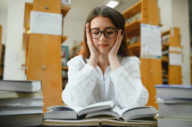 Education, high school, university, learning and people concept. Smiling student girl reading book.