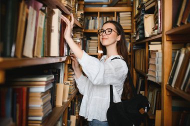 Education, high school, university, learning and people concept. Smiling student girl reading book.