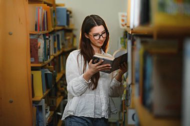 Education, high school, university, learning and people concept. Smiling student girl reading book.