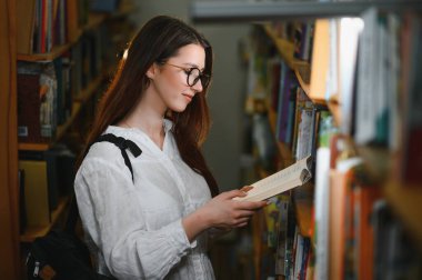 Education, high school, university, learning and people concept. Smiling student girl reading book.