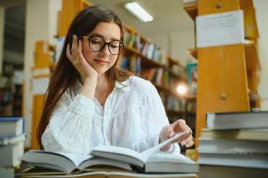 Education, high school, university, learning and people concept. Smiling student girl reading book.