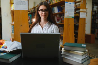 bir kitaplıktaki güzel bir öğrenci portresi.