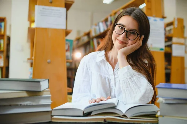 図書館で 高校図書館で働く本を持つかなり女性の学生 — ストック写真
