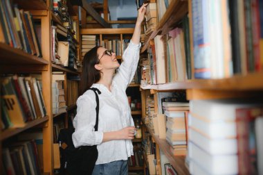 Kütüphanede. Lise kütüphanesinde kitapları olan güzel bir kız öğrenci.