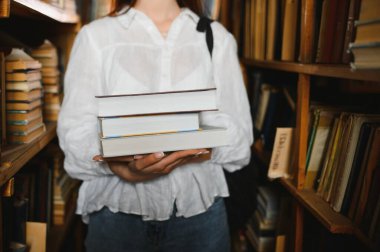 Kütüphanede. Lise kütüphanesinde kitapları olan güzel bir kız öğrenci.