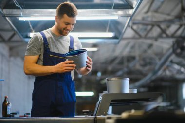 Baskı fabrikasındaki modern ambalaj makinesinin üretim sürecini kontrol eden işçilerin portresi.