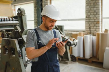 Yönetim ekibi, mühendis ya da ustabaşı. Fabrikadaki endüstriyel üretim yönetimi ile ilgili iş bilgilerini telefonla kontrol ediyoruz. Takım çalışması konsepti.