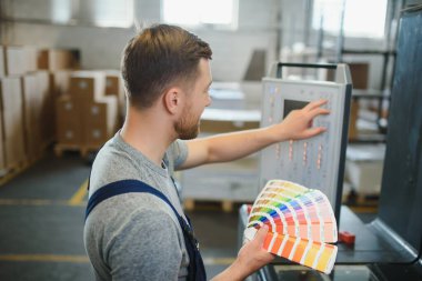 Baskı imalatında elinde renk örnekleriyle duran daktilografın komik portresi.