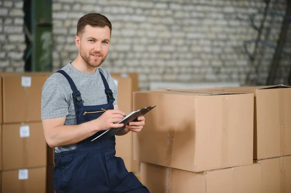 Warehouse worker carrying a carton for delivery to production stock