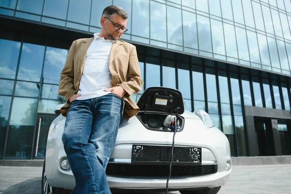 Lässiger Mann Der Nähe Von Elektroauto Wartet Auf Das Ende — Stockfoto