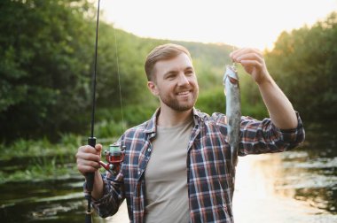 Güneş doğarken flyfishing genç adam.