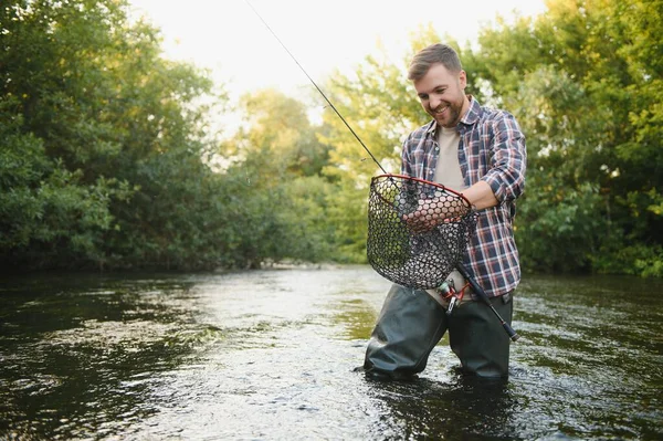 Pescatore Raccogliendo Grande Trota Arcobaleno Dalla Sua Rete Pesca — Foto Stock