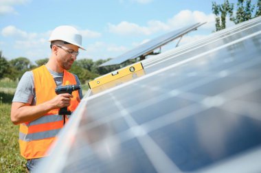 Dışarıda güneş panelleri kuran işçiler.