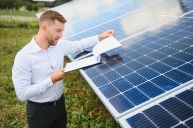 Engineer at solar power station with solar panel. Practical lessons on renewable energy power plants