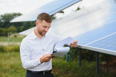 Engineer at solar power station with solar panel. Practical lessons on renewable energy power plants