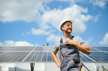 Dışarıda güneş panelleri kuran işçiler.