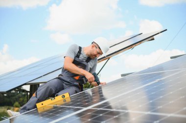 Dışarıda güneş panelleri kuran işçiler.