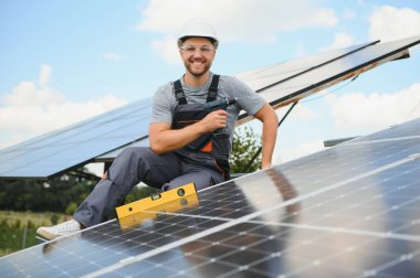 Dışarıda güneş panelleri kuran işçiler.