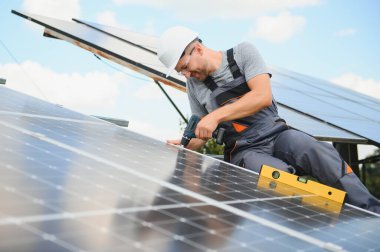 Dışarıda güneş panelleri kuran işçiler.