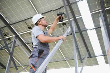 Dışarıda güneş panelleri kuran işçiler.