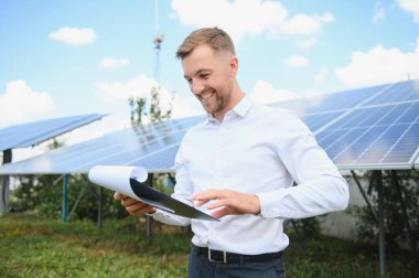 Dışarıda güneş panelleri kuran işçiler.