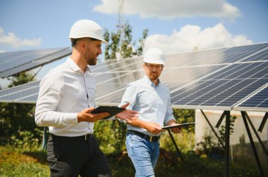 Dışarıda güneş panelleri kuran işçiler.