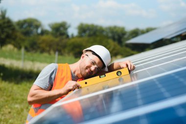 Dışarıda güneş panelleri kuran işçiler.