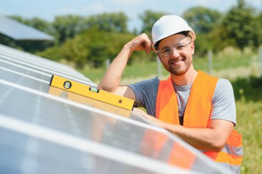 Dışarıda güneş panelleri kuran işçiler.