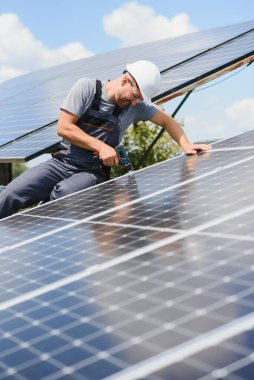 Dışarıda güneş panelleri kuran işçiler.