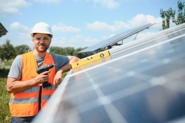 Dışarıda güneş panelleri kuran işçiler.