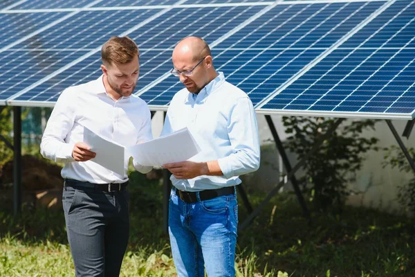 The solar farm(solar panel) with two engineers walk to check the operation of the system, Alternative energy to conserve the world's energy, Photovoltaic module idea for clean energy production.