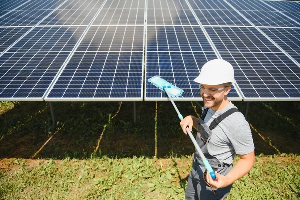 Worker cleaning solar panels after installation outdoors.
