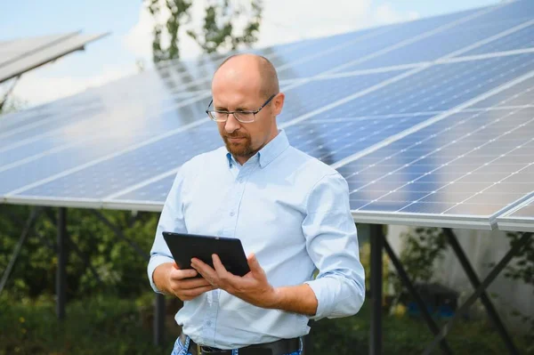 Solar energy. Young business man near the solar panels to power plants