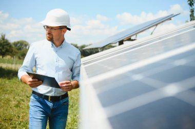 Dışarıda güneş panelleri kuran işçiler.