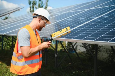 Dışarıda güneş panelleri kuran işçiler.