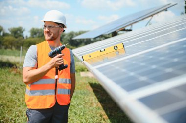 Dışarıda güneş panelleri kuran işçiler.