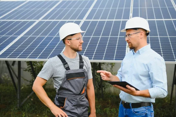 near the solar panels, the employee shows the work plan to the boss