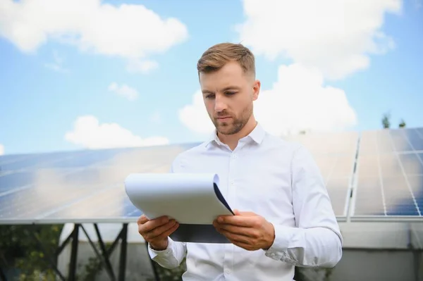 Solar energy. Young business man near the solar panels to power plants