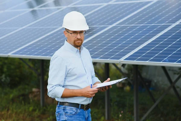 Engineer at solar power station with solar panel. Practical lessons on renewable energy power plants