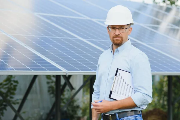 The portrait of a proud engineer smiles satisfied with his successful work. Concept: renewable energy, technology, electricity, service, green power.