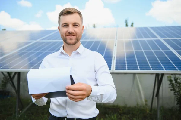 Solar energy. Young business man near the solar panels to power plants