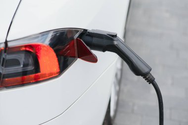 Şarj ediliyor bir elektrikli otomobil takılı güç kaynağı ile Hibrid araba elektrikli şarj istasyonu yakın