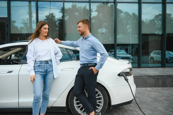 Happy Young Adult Man Smiling Woman Charging Electric Car — Stock Fotó